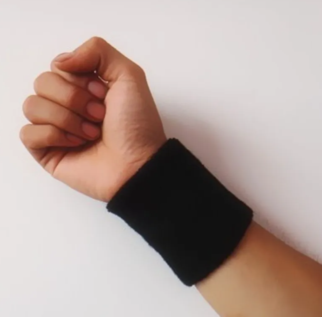 Hand wearing a black wristband on a white background
